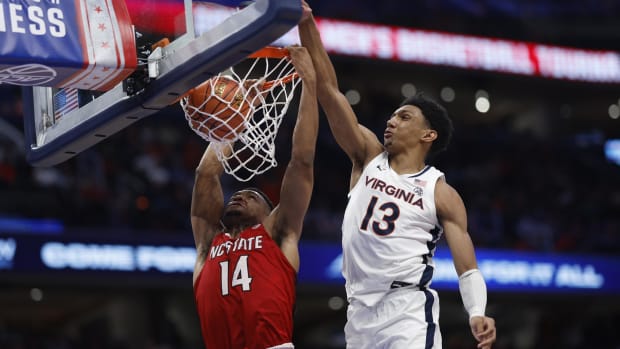 Mar 15, 2024; Washington, D.C., USA; North Carolina State Wolfpack guard Casey Morsell (14) dunks the ball as Virginia Cavaliers guard Ryan Dunn (13) defends in the second half at Capital One Arena. Mandatory Credit: Geoff Burke-USA TODAY Sports