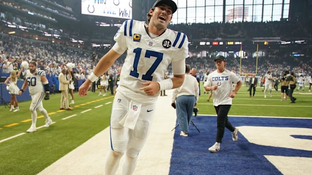 Colts QB Daniel Jones (white and blue jersey) excitedly runs through the end zone after a big-time win.