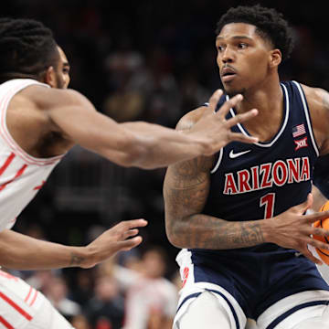 Arizona Wildcats guard Caleb Love (1) attempts to dribble the ball past Houston Cougars forward Joseph Tugler (11) during the second half for the Big 12 Conference Tournament Championship game at T-Mobile Center.