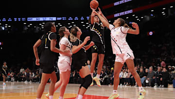 McDonald's All American East forward Jaliya Davis shoots the ball against McDonald's All American West forward Sienna Betts.