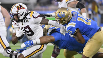 Oct 12, 2024; Pasadena, California, USA; Minnesota Golden Gophers wide receiver Daniel Jackson (9) tries to run against UCLA Bruins defensive lineman Siale Taupaki (92) and defensive back Ramon Henderson (11) during the first quarter at Rose Bowl. Mandatory Credit: Robert Hanashiro-Imagn Images