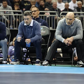 Penn State wrestling coach Cael Sanderson and his staff watch the 141-pound championship match at the 2024 NCAA Wrestling Championships. 