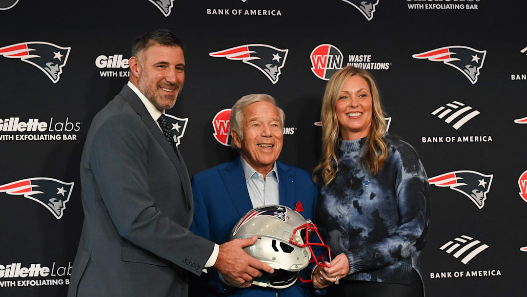 Jan 13, 2025; Foxborough, MA, USA; Mike Vrabel (l) and his wife Jennifer (r) pose for a photo with New England Patriots owner Robert Kraft (c) after a press conference at Gillette Stadium to introduce Vrabel as the Patriots head coach . Mandatory Credit: Eric Canha-Imagn Images