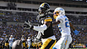 Sep 22, 2024; Pittsburgh, Pennsylvania, USA; Pittsburgh Steelers wide receiver George Pickens (14) reaches for a pass while being defended by Los Angeles Chargers cornerback Asante Samuel Jr. (26) during the second half at Acrisure Stadium. Mandatory Credit: Barry Reeger-Imagn Images