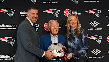 Jan 13, 2025; Foxborough, MA, USA; Mike Vrabel (l) and his wife Jennifer (r) pose for a photo with New England Patriots owner Robert Kraft (c) after a press conference at Gillette Stadium to introduce Vrabel as the Patriots head coach . Mandatory Credit: Eric Canha-Imagn Images