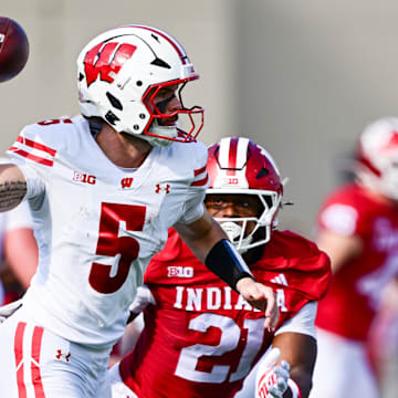 Nov 15, 2025; Bloomington, Indiana, USA; Wisconsin Badgers quarterback Carter Smith (5) throws a pass in front of Indiana Hoosiers linebacker Rolijah Hardy (21) during the second quarter at Memorial Stadium.