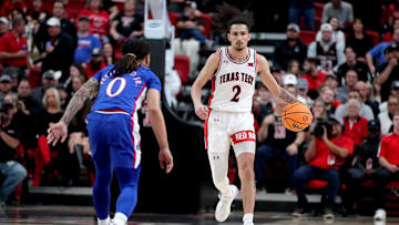 Jan 3, 2023; Lubbock, Texas, USA;  Texas Tech Red Raiders guard Pop Issacs (2) brings the ball up court against Kansas Jayhawks guard Bobby Pettiford Jr (0) in the first half at United Supermarkets Arena. Mandatory Credit: Michael C. Johnson-Imagn Images