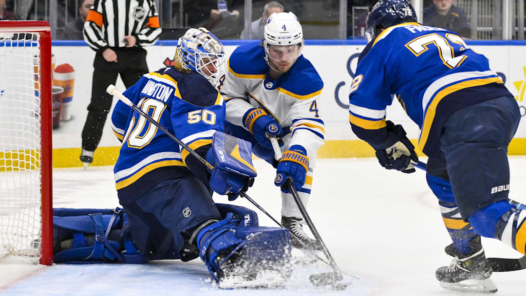 Dec 29, 2024; St. Louis, Missouri, USA;  St. Louis Blues goaltender Jordan Binnington (50) and defenseman Justin Faulk (72) defend the net against Buffalo Sabres defenseman Bowen Byram (4) during the first period at Enterprise Center. Mandatory Credit: Jeff Curry-Imagn Images