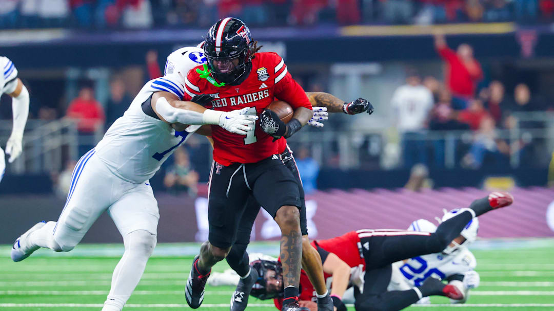 Dec 6, 2025; Arlington, TX, USA;  Texas Tech Red Raiders tight end Terrance Carter Jr. (7) picks up a fumble and runs as BYU Cougars defensive lineman Logan Lutui (7) defends during the second quarter at AT&T Stadium. Mandatory Credit: Kevin Jairaj-Imagn Images