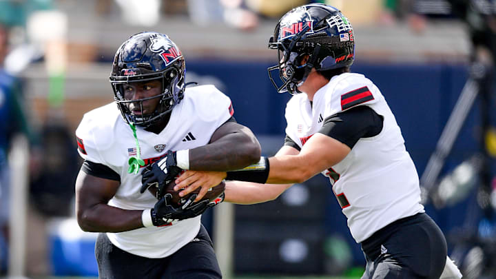 Sep 7, 2024; South Bend, Indiana, USA; Northern Illinois Huskies quarterback Ethan Hampton (2) hands off to running back Antario Brown (1) in the first quarter against the Notre Dame Fighting Irish at Notre Dame Stadium. Mandatory Credit: Matt Cashore-Imagn Images