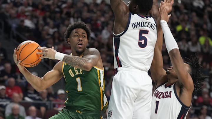March 10, 2025; Las Vegas, NV, USA; San Francisco Dons guard Malik Thomas (1) is defended by Gonzaga Bulldogs forward Emmanuel Innocenti (5) and guard Michael Ajayi (1) during the second half in the semifinal of the West Coast Conference tournament at Orleans Arena. Mandatory Credit: Kyle Terada-Imagn Images