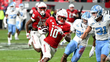 Nov 25, 2023; Raleigh, North Carolina, USA; North Carolina State Wolfpack receiver KC Concepcion (10) runs after a catch against North Carolina Tar Heels defensive back Will Hardy (31) during the first half at Carter-Finley Stadium. Mandatory Credit: Rob Kinnan-Imagn Images