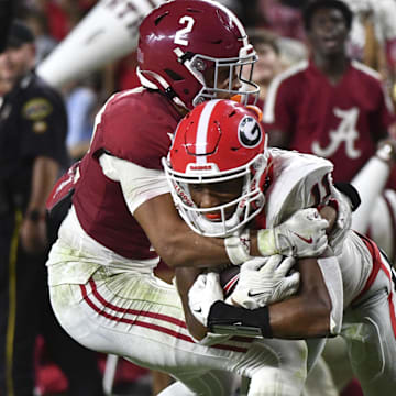 Sep 28, 2024; Tuscaloosa, Alabama, USA;  Georgia Bulldogs wide receiver Arian Smith (11) is tackled by Alabama Crimson Tide defensive back Zabien Brown (2) after a long reception to set up a touchdown at Bryant-Denny Stadium. Alabama defeated Georgia 41-34. Mandatory Credit: Gary Cosby Jr.-Imagn Images