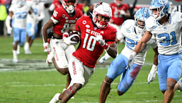Nov 25, 2023; Raleigh, North Carolina, USA; North Carolina State Wolfpack receiver KC Concepcion (10) runs after a catch against North Carolina Tar Heels defensive back Will Hardy (31) during the first half at Carter-Finley Stadium. Mandatory Credit: Rob Kinnan-Imagn Images
