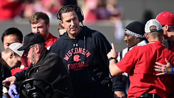 Nov 15, 2025; Bloomington, Indiana, USA; Wisconsin Badgers head coach Luke Fickell stands in the crowd surrounding an injured Wisconsin Badgers running back Gideon Ituka during the second half against the against the Indiana Hoosiers at Memorial Stadium. Mandatory Credit: Marc Lebryk-Imagn Images