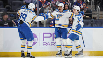 Nov 22, 2025; Elmont, New York, USA;  St. Louis Blues center Brayden Schenn (10) celebrates with left wing Pavel Buchnevich (89) and right wing Dalibor Dvorsky (54) after scoring a goal in the first period against the New York Islanders at UBS Arena. Mandatory Credit: Wendell Cruz-Imagn Images