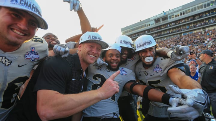 Dec 2, 2017; Orlando, FL, USA; UCF Knights head coach Scott Frost celebrates with players after defeating the Memphis Tigers in double overtime at Spectrum Stadium. Mandatory Credit: Matt Stamey-USA TODAY Sports