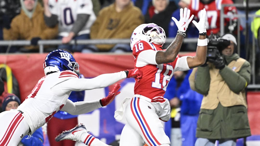 Dec 1, 2025; Foxborough, Massachusetts, USA; New England Patriots wide receiver Kyle Williams (18) catches a pass for a touchdown against New York Giants cornerback Paulson Adebo (21) during the second quarter at Gillette Stadium. Mandatory Credit: Eric Canha-Imagn Images