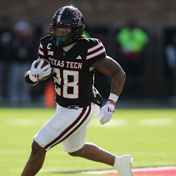 Nov 30, 2024; Lubbock, Texas, USA;  Texas Tech Red Raiders running back Tahj Brooks (28) carries the ball against the West Virginia Mountaineers in the first half at Jones AT&T Stadium and Cody Campbell Field. Mandatory Credit: Michael C. Johnson-Imagn Images