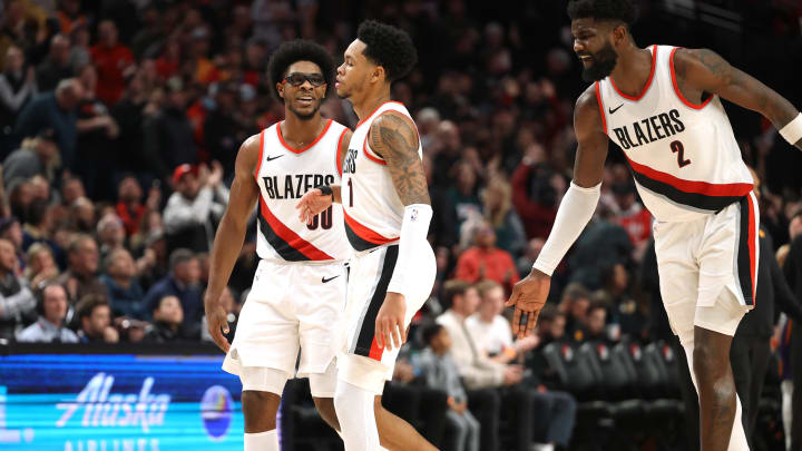 Dec 19, 2023; Portland, Oregon, USA;  Portland Trail Blazers guard Scoot Henderson (00), left, and center Deandre Ayton (2) celebrates with guard Anfernee Simons (1) after Simons scored a basket to seal the 109-104 win over Phoenix Suns at Moda Center. Mandatory Credit: Jaime Valdez-USA TODAY Sports