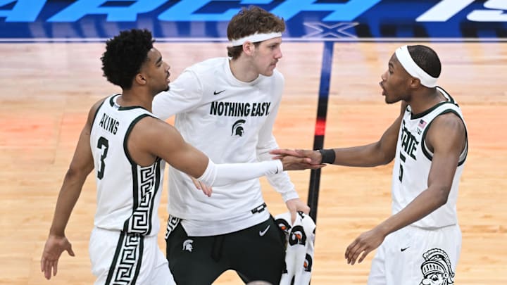 Mar 14, 2025; Indianapolis, IN, USA; Michigan State Spartans guard Jaden Akins (3) and Michigan State Spartans guard Tre Holloman (5) high-five during the first half against the Oregon Ducks at Gainbridge Fieldhouse. Mandatory Credit: Robert Goddin-Imagn Images