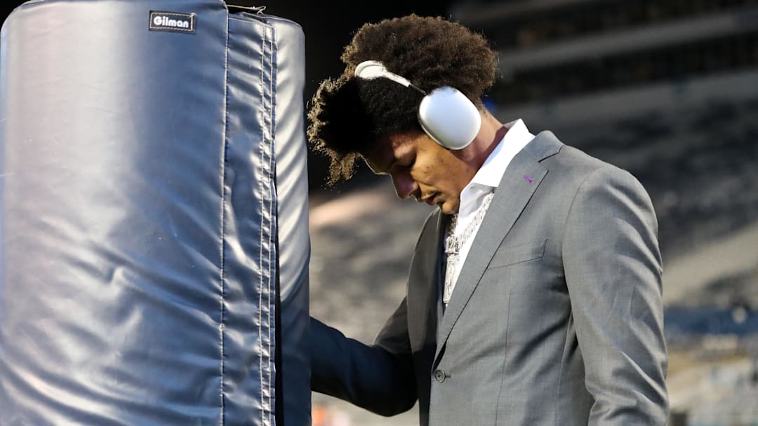 Nov 9, 2024; University Park, Pennsylvania, USA; Washington Huskies wide receiver Denzel Boston (12) leans against the goal post for a quiet moment prior to the game against the Penn State Nittany Lions at Beaver Stadium. Mandatory Credit: Matthew O'Haren-Imagn Images