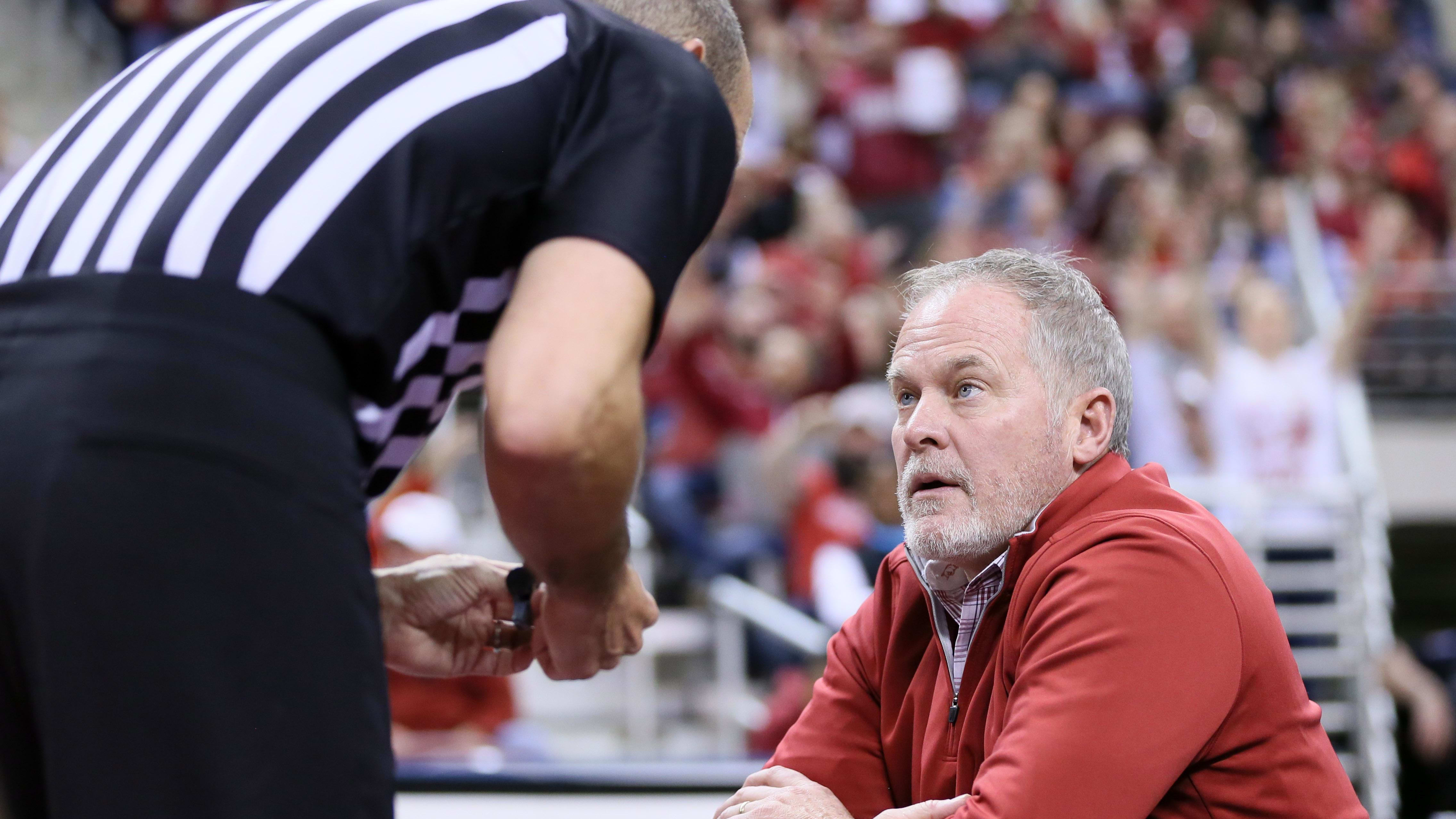 Arkansas Razorbacks athletic director Hunter Yurachek talks with a referee.