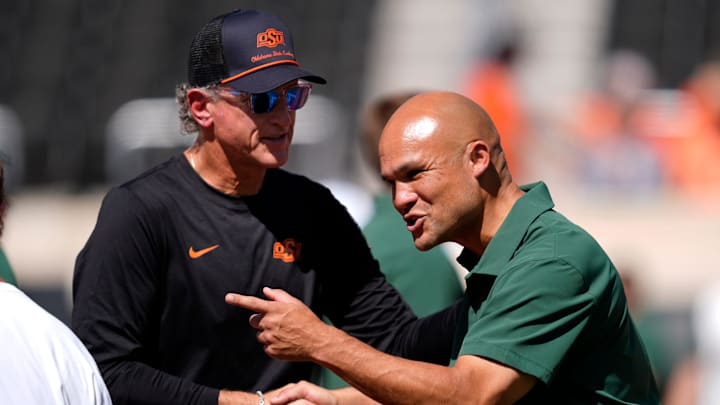 Oklahoma State Interim Head Coach/Offensive Coordinator Doug Meacham and Dave Aranda talk before the college football game between the Oklahoma State Cowboys and the Baylor Bears at Boone Pickens Stadium in Stillwater, Okla., Saturday, Sept. 27, 2025. Oklahoma State Interim Head Coach/Offensive Coordinator Doug Meacham and Dave Aranda talk before the college football game between the Oklahoma State Cowboys and the Baylor Bears at Boone Pickens Stadium in Stillwater, Okla., Saturday, Sept. 27, 2025.