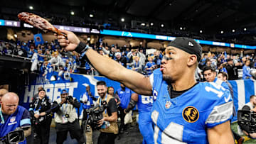Detroit Lions wide receiver Amon-Ra St. Brown (14) waves a turkey leg at fans to celebrate 23-20 win over Chicago Bears at Ford Field in Detroit on Thursday, Nov. 28, 2024.