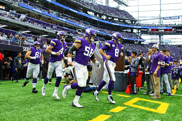 Kirk Cousins (8) and Sean Mannion (4) run onto the field before a game in 2019.