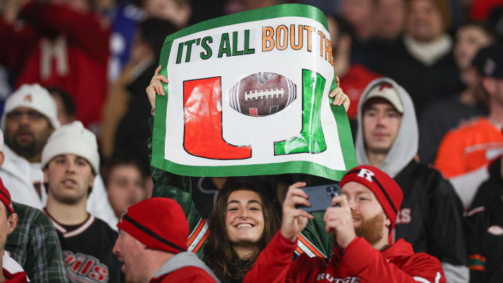 Dec 28, 2023; Bronx, NY, USA; A Miami Hurricanes fan holds a sign during the second half of the 2023 Pinstripe Bowl in front of Rutgers Scarlet Knights fans at Yankee Stadium. Mandatory Credit: Vincent Carchietta-USA TODAY Sports