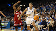 Jan 21, 2025; Los Angeles, California, USA;  UCLA Bruins guard Kobe Johnson (0) dribbles the ball against Wisconsin Badgers guard Kamari McGee (4) during the first half at Pauley Pavilion presented by Wescom. Mandatory Credit: Kiyoshi Mio-Imagn Images
