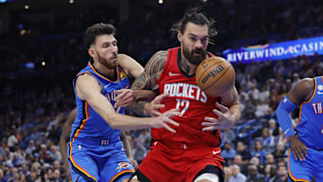 Oct 21, 2025; Oklahoma City, Oklahoma, USA; Houston Rockets center Steven Adams (12) and Oklahoma City Thunder center Chet Holmgren (7) reach for a loose ball during the second half at Paycom Center. Mandatory Credit: Alonzo Adams-Imagn Images