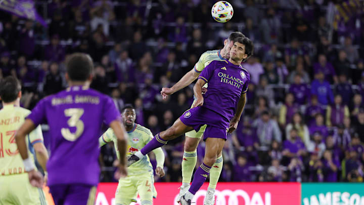 Nov 30, 2024; Orlando, Florida, USA; Orlando City forward Ramiro Enrique (7) battles for a header against New York Red Bulls defender Dylan Nealis (12) during the first half in the 2024 MLS Cup Eastern Conference Final match at Inter&Co Stadium. Mandatory Credit: Mike Watters-Imagn Images