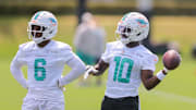 Miami Dolphins wide receiver Tyreek Hill tosses a football as Malik Washington looks on during mandatory NFL minicamp