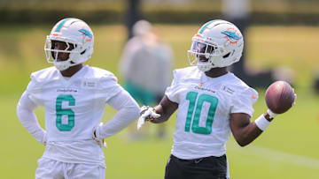 Miami Dolphins wide receiver Tyreek Hill tosses a football as Malik Washington looks on during mandatory NFL minicamp