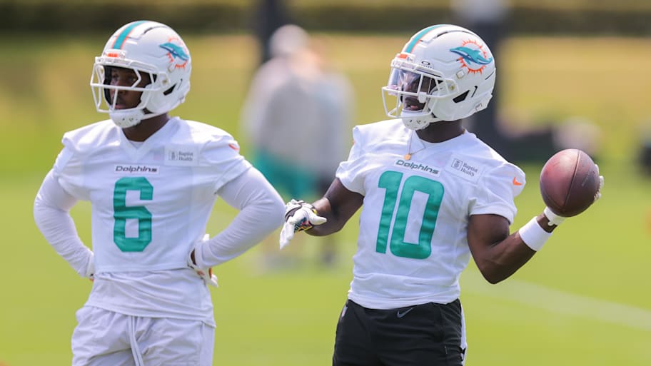 Miami Dolphins wide receiver Tyreek Hill (10) tosses a football as wide receiver Malik Washington (6) looks on during mandatory minicamp at Hard Rock Stadium. | Sam Navarro-Imagn Images