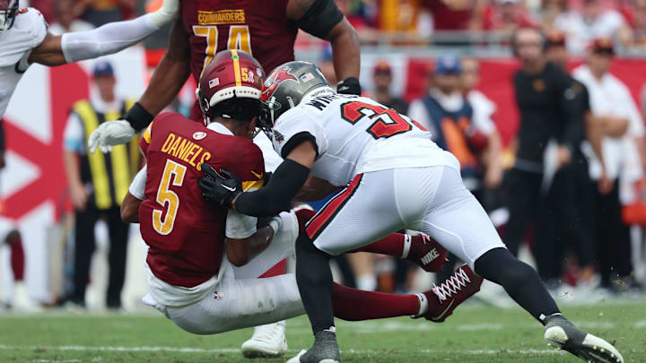 Sep 8, 2024; Tampa, Florida, USA;  Tampa Bay Buccaneers safety Antoine Winfield Jr. (31) hits Washington Commanders quarterback Jayden Daniels (5) in the helment during the first half at Raymond James Stadium. Mandatory Credit: Kim Klement Neitzel-Imagn Images