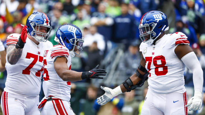 Oct 30, 2022; Seattle, Washington, USA; New York Giants running back Saquon Barkley (26) celebrates with guard Jack Anderson (77) and offensive tackle Andrew Thomas (78) after rushing for a touchdown against the Seattle Seahawks during the second quarter at Lumen Field.