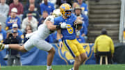 Nov 15, 2025; Pittsburgh, Pennsylvania, USA;  Notre Dame Fighting Irish defensive lineman Joshua Burnham (left) tackles Pittsburgh Panthers quarterback Mason Heintschel (6) during the first quarter at Acrisure Stadium. Mandatory Credit: Charles LeClaire-Imagn Images