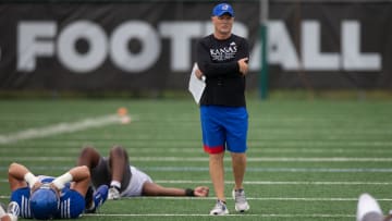 Kansas defensive coordinator Brian Borland surveys his players as they are lead in a stretching exercise during Thursday's practice.