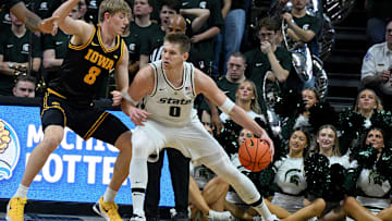 Dec 2, 2025; East Lansing, Michigan, USA;  Michigan State Spartans forward Kaleb Glenn (8) moves the ball against Iowa Hawkeyes forward Cooper Koch (8) during the first half at Jack Breslin Student Events Center. Mandatory Credit: Dale Young-Imagn Images