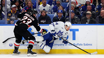 Dec 20, 2024; Buffalo, New York, USA;  Buffalo Sabres defenseman Mattias Samuelsson (23) checks Toronto Maple Leafs center Auston Matthews (34) as he goes for the puck during the first period at KeyBank Center. Mandatory Credit: Timothy T. Ludwig-Imagn Images