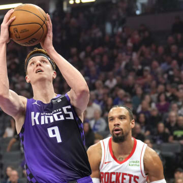 Mar 10, 2024; Sacramento, California, USA; Sacramento Kings guard Kevin Huerter (center) shoots against Houston Rockets forward Dillon Brooks (right) during the first quarter at Golden 1 Center. Mandatory Credit: Darren Yamashita-USA TODAY Sports