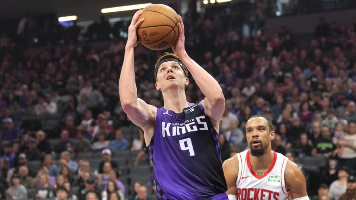 Mar 10, 2024; Sacramento, California, USA; Sacramento Kings guard Kevin Huerter (center) shoots against Houston Rockets forward Dillon Brooks (right) during the first quarter at Golden 1 Center. Mandatory Credit: Darren Yamashita-USA TODAY Sports