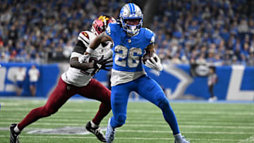 Detroit Lions running back Jahmyr Gibbs runs the ball against Washington Commanders defensive back Quan Martin during the fourth quarter in a 2025 NFC divisional round game at Ford Field. 