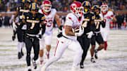 Nov 30, 2024; Columbia, Missouri, USA; Arkansas Razorbacks running back Ja'Quinden Jackson (22) scores a touchdown as Missouri Tigers safety Marvin Burks Jr. (1) looks on during the second half at Faurot Field at Memorial Stadium. Mandatory Credit: Denny Medley-Imagn Images