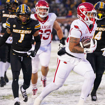 Nov 30, 2024; Columbia, Missouri, USA; Arkansas Razorbacks running back Ja'Quinden Jackson (22) scores a touchdown as Missouri Tigers safety Marvin Burks Jr. (1) looks on during the second half at Faurot Field at Memorial Stadium. Mandatory Credit: Denny Medley-Imagn Images