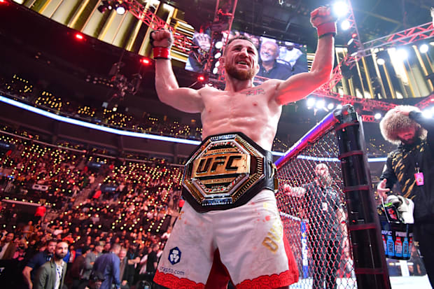 Merab Dvalishvili (red gloves) celebrates after winning a UFC bantamweight title fight against Umar Nurmagomedov.