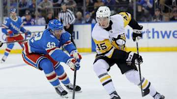 Oct 7, 2025; New York, New York, USA; Pittsburgh Penguins defenseman Harrison Brunicke (45) plays the puck against New York Rangers center Noah Laba (42) during the third period at Madison Square Garden. Mandatory Credit: Brad Penner-Imagn Images